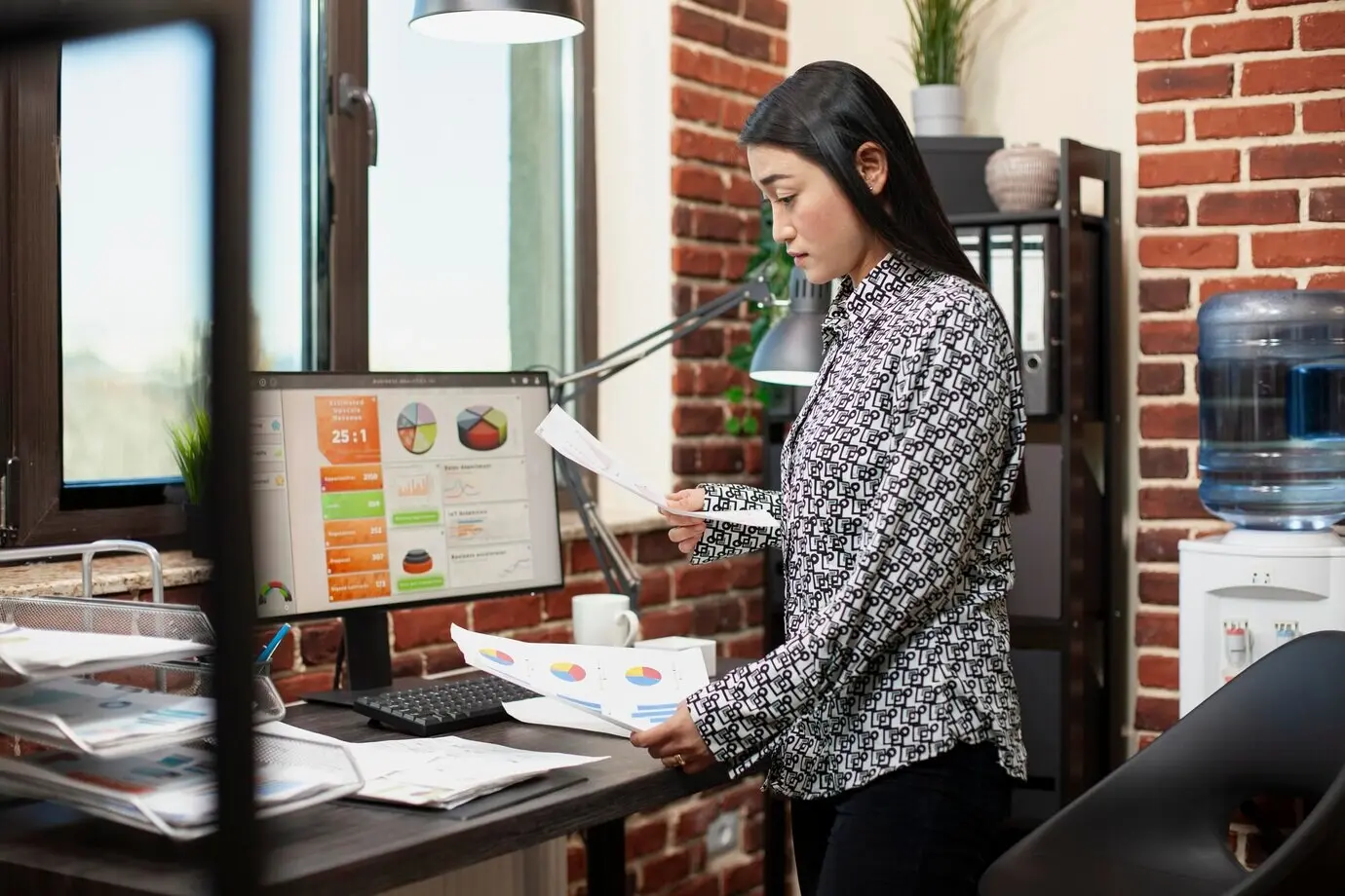 Женщина стоит и просматривает документы.