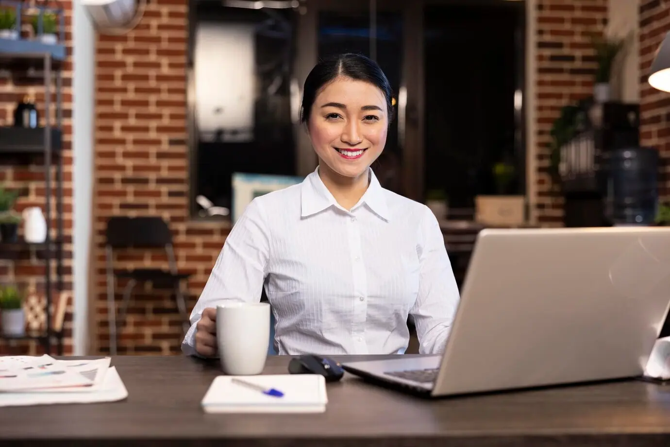 Азиатская сотрудница улыбается в камеру